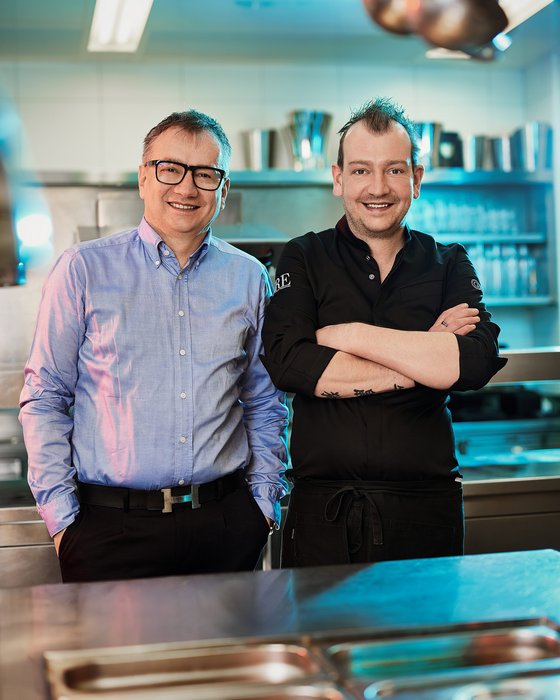 Hotel Sonnenhof Zwei Männer, ein Koch und ein Mann im Hemd, in einer Restaurantküche