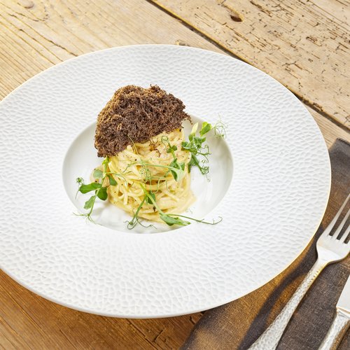 Hotel Sonnenhof Spaghetti mit grünen Kräutern und knusprigem Brot auf weißem Teller