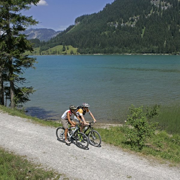 Hotel Sonnenhof Zwei Radfahrer auf einem Waldweg neben einem See in den Bergen