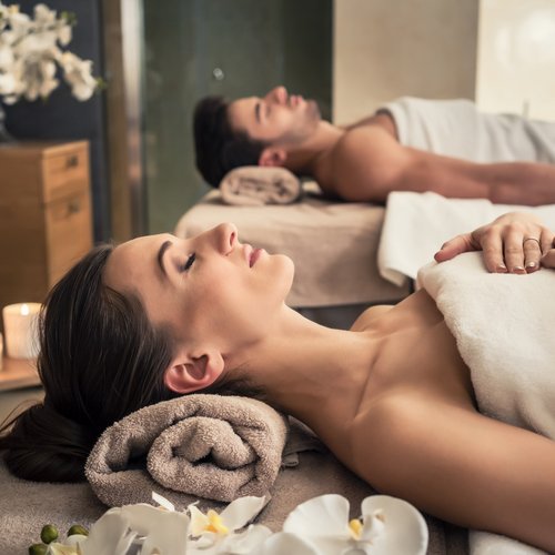 Hotel Sonnenhof Paar entspannt bei Paarmassage im Spa mit Kerzen und Blumen