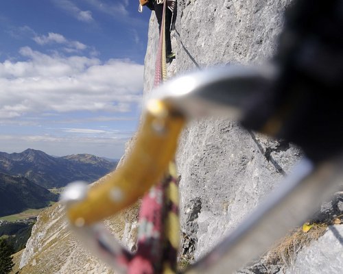 Hotel Sonnenhof Kletterer gesichert mit Seilen erklimmt steile Felswand