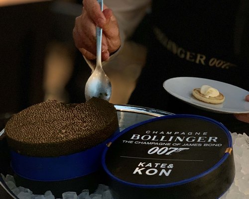 Hotel Sonnenhof Person schöpft Kaviar aus Dose auf Eis mit Teller und Brötchen