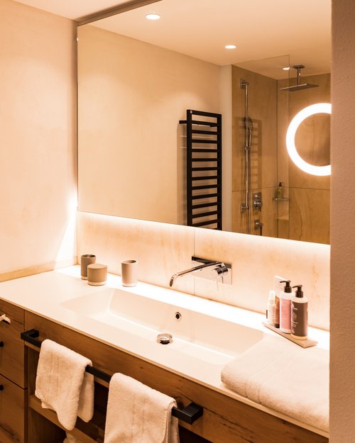 Hotel Sonnenhof Modern bathroom with large mirror, sink, and towels