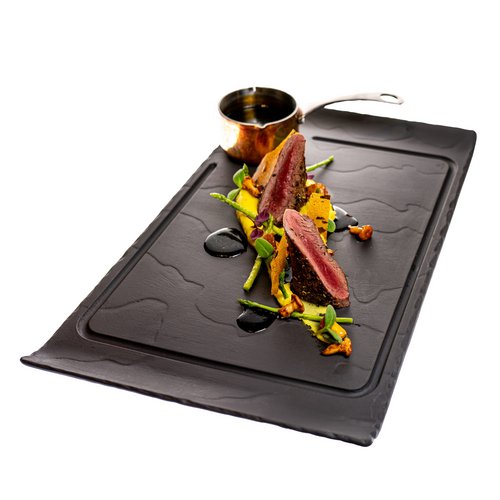 Hotel Sonnenhof Gourmetgericht mit rosa Fleisch, grünem Gemüse und Sauce auf schwarzem Teller