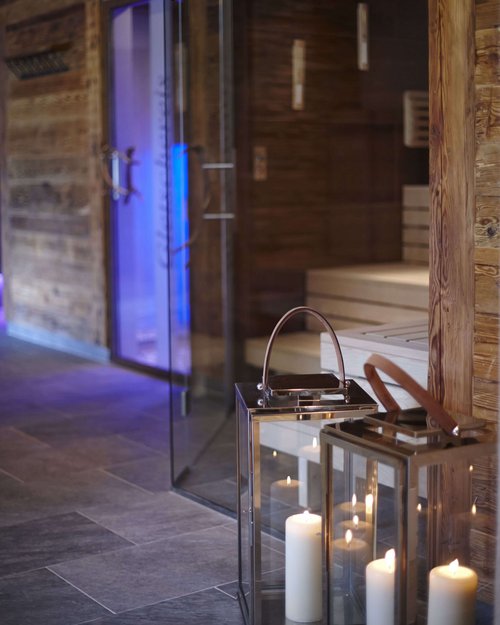 Hotel Sonnenhof Gemütlicher Saunabereich mit brennenden Kerzen in Laternen und Holzwänden