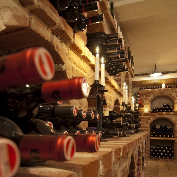 Hotel Sonnenhof Weinkeller mit Backsteinregalen, Weinflaschen und Kerzenbeleuchtung