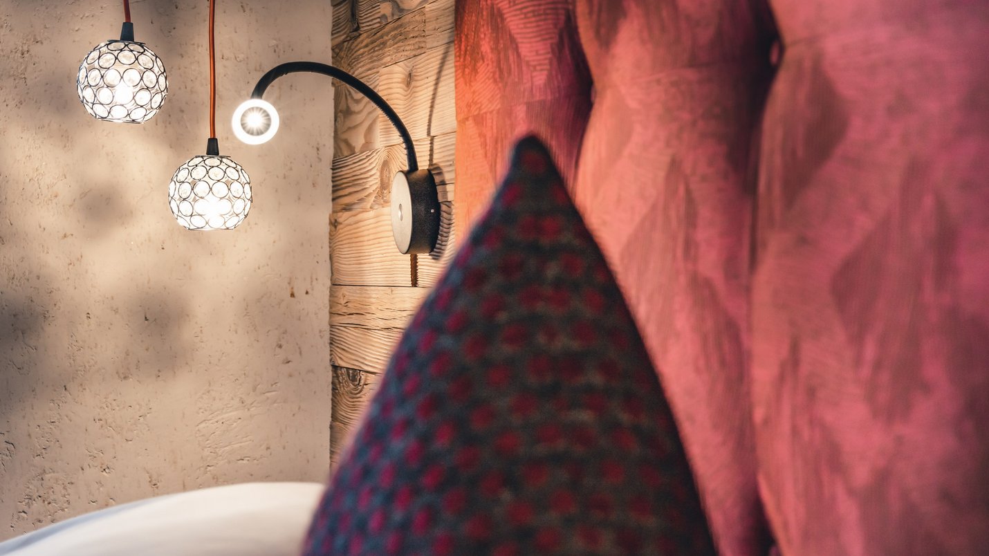 Hotel Sonnenhof Moderne Wandlampen neben einem gepolsterten roten Kopfteil an Holzwand