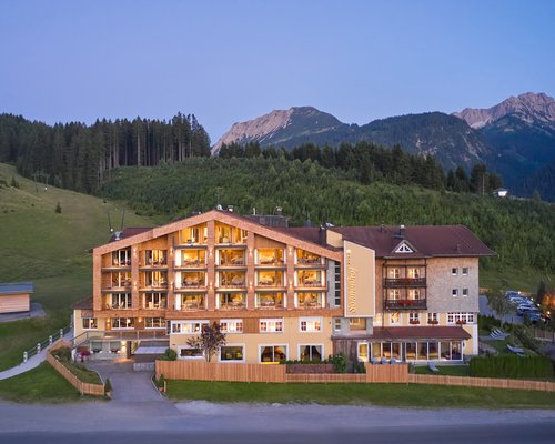 Hotel Sonnenhof Hotel mit beleuchteten Fenstern in den Bergen bei Abenddämmerung