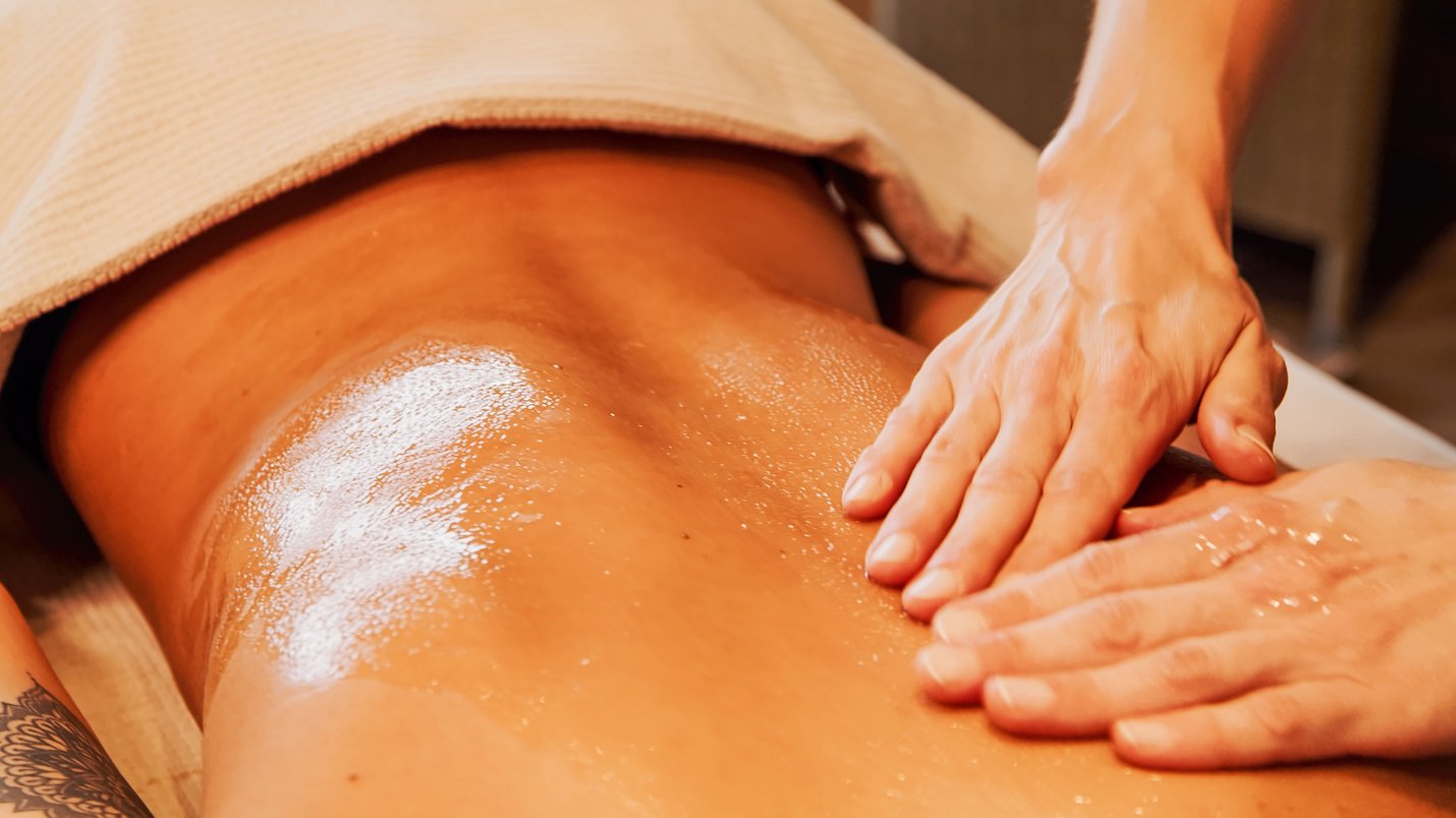 Hotel Sonnenhof Ölmassage auf dem Rücken einer Person in einem Spa