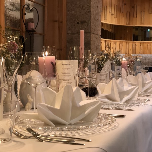 Hotel Sonnenhof Festively set table with napkins, candles, and glasses in rustic room