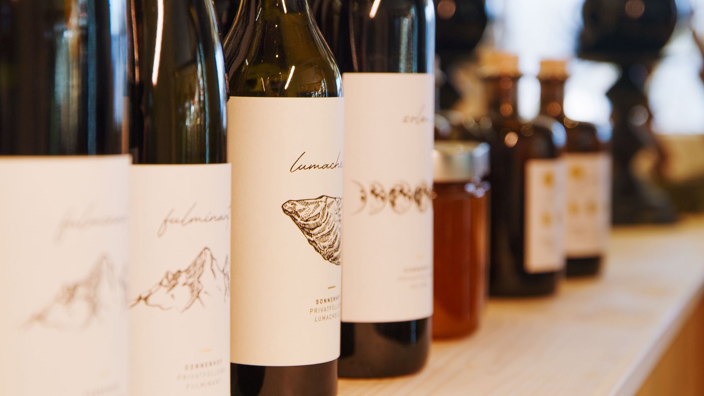 Hotel Sonnenhof Verschiedene Flaschen mit minimalistischen Etiketten auf Holzoberfläche