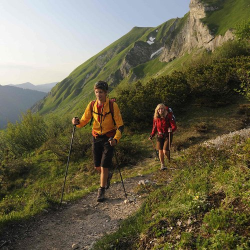 Hotel Sonnenhof Two hikers with trekking poles on a mountain trail in sunny weather