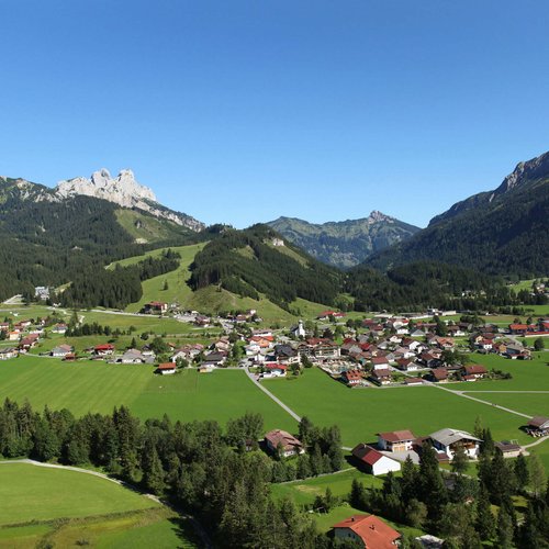 Hotel Sonnenhof Village in green mountain landscape under clear blue sky