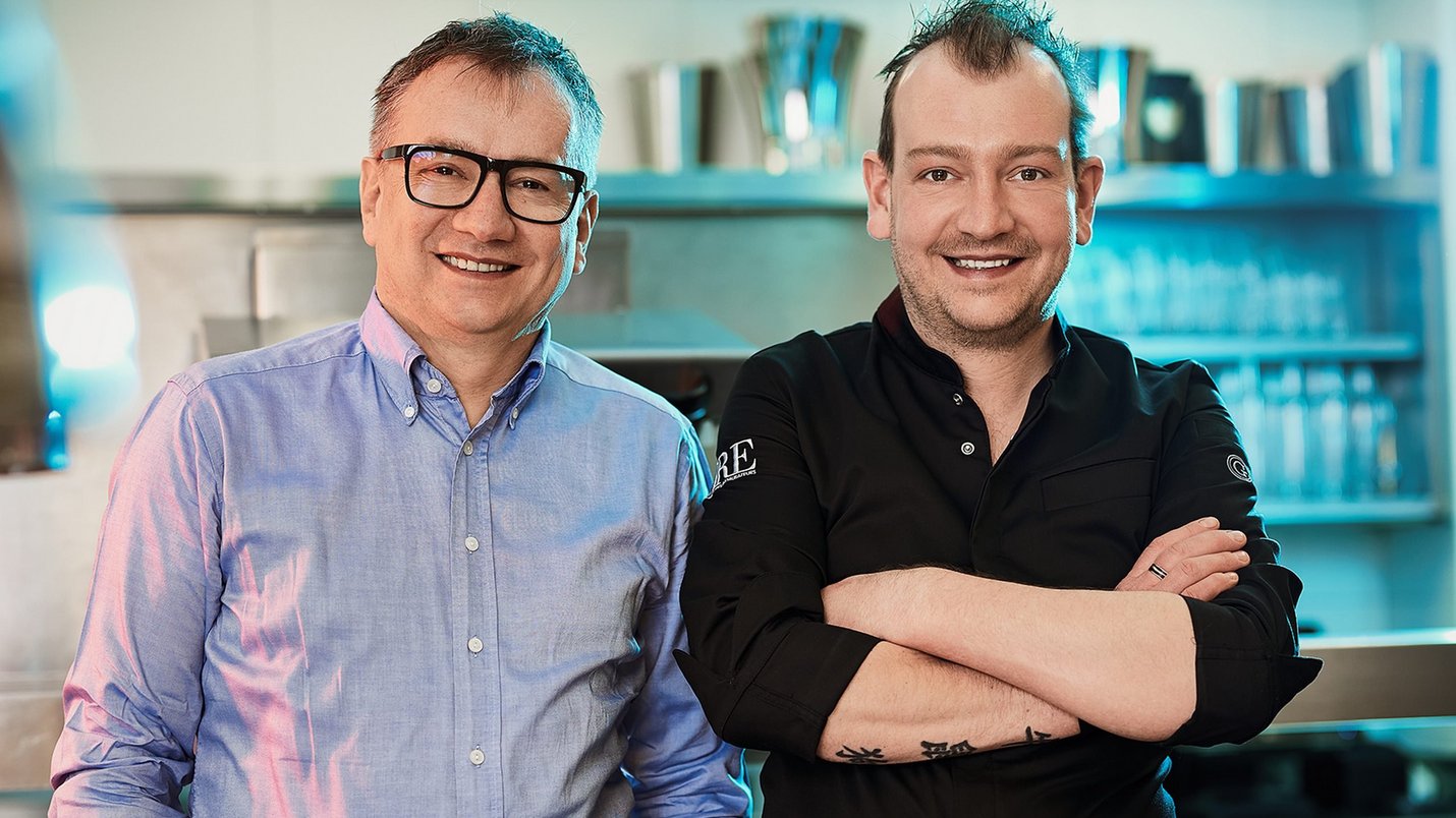 Hotel Sonnenhof Zwei Männer, ein Koch und ein Mann im Hemd, in einer Restaurantküche
