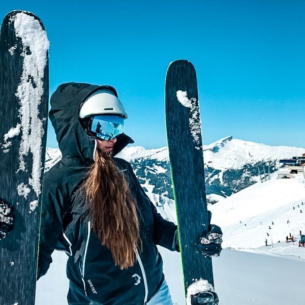 Hotel Sonnenhof Frau mit Ski und Helm auf schneebedecktem Berg bei sonnigem Wetter