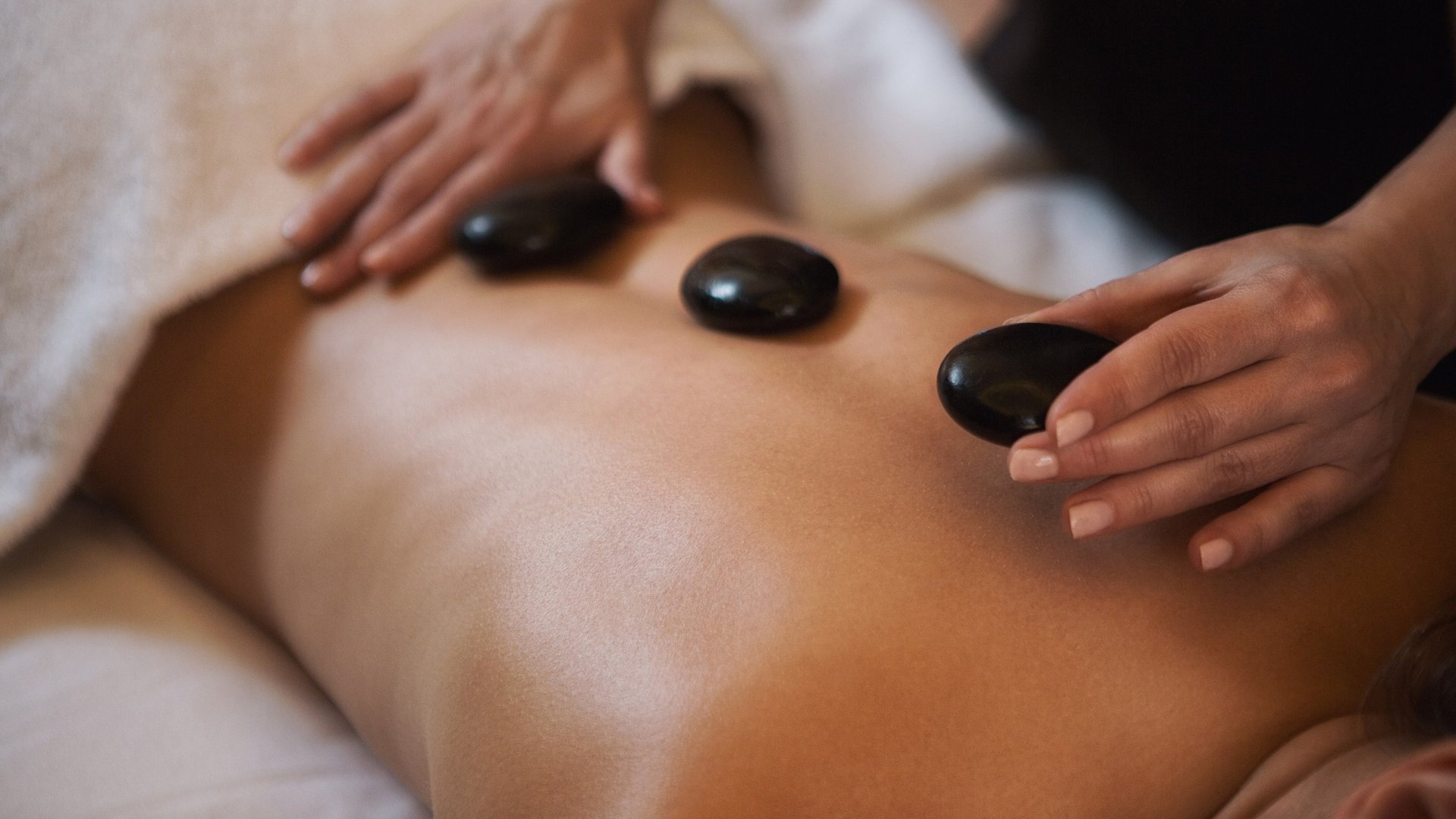 Hotel Sonnenhof Person receiving hot stone massage on bare back