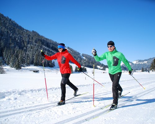 Hotel Sonnenhof Zwei Personen beim Langlaufen auf schneebedeckter Loipe bei sonnigem Winterwetter