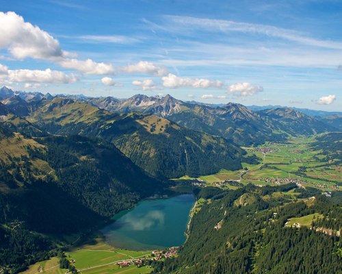 Hotel Sonnenhof Berglandschaft mit See, Wäldern und kleinen Dörfern unter blauem Himmel