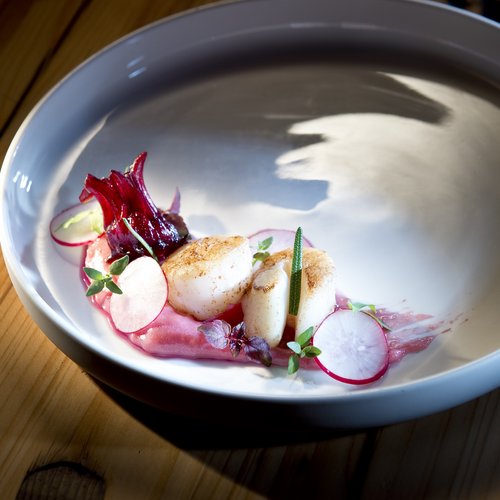 Hotel Sonnenhof Gebratene Jakobsmuscheln mit Radieschen und roter Sauce auf weißem Teller