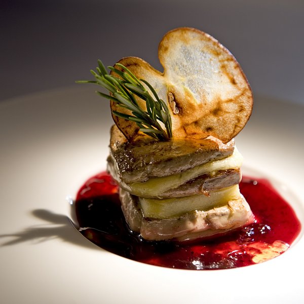 Hotel Sonnenhof Gourmetgericht mit Fleisch, Apfelscheiben, Rosmarin und roter Sauce auf weißem Teller