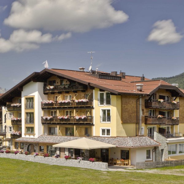 Hotel Sonnenhof Hotelgebäude in alpiner Landschaft mit Balkonblumen und Bergen im Hintergrund