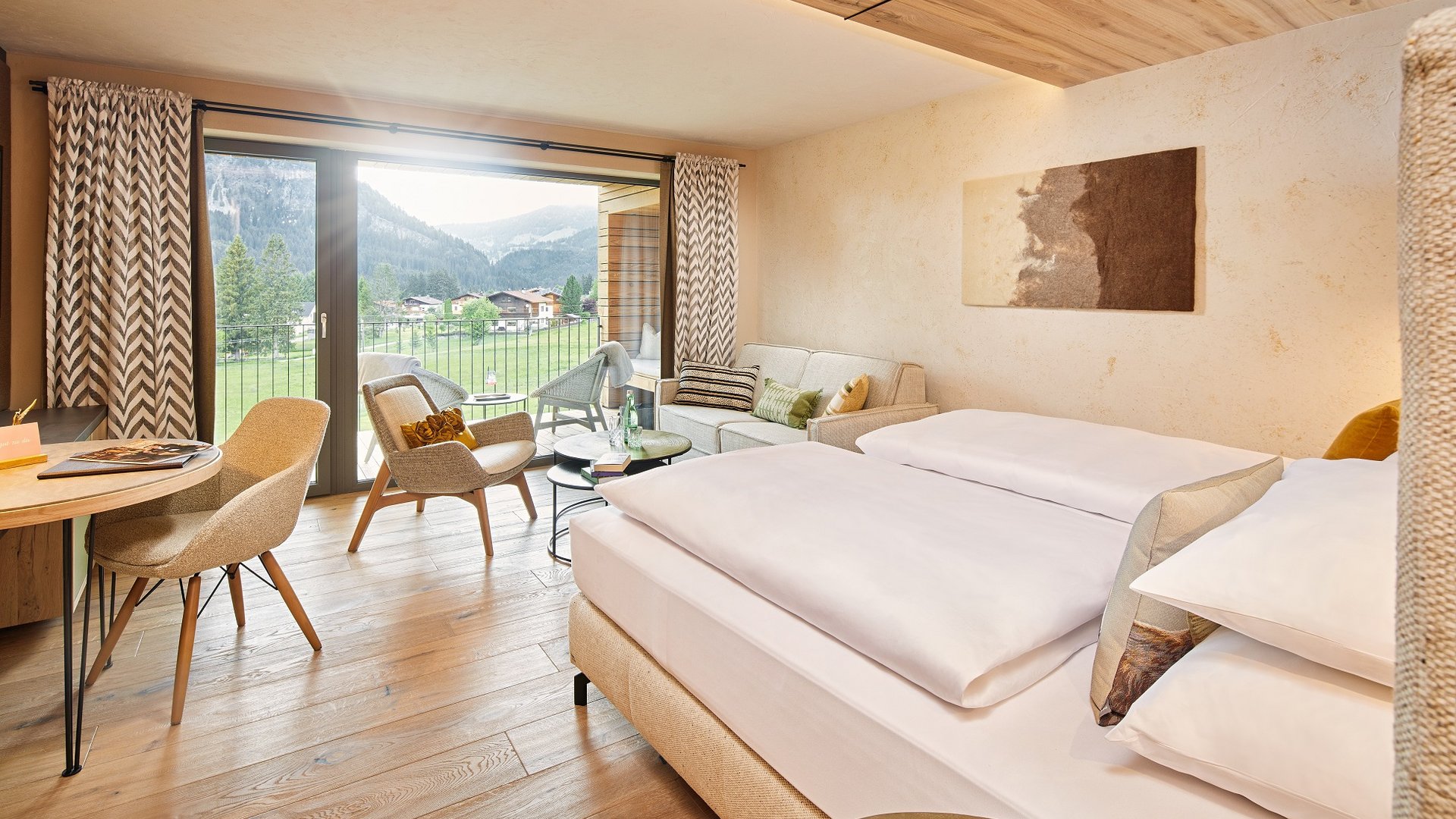 Hotel Sonnenhof Helles Hotelzimmer mit Doppelbett, Sitzecke und Bergblick vom Balkon