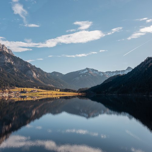 Hotel Sonnenhof Mountain lake reflecting surrounding peaks and forested slopes under blue sky