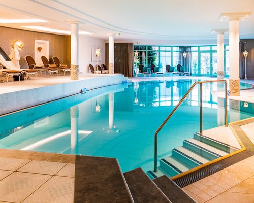 Hotel Sonnenhof Hallenbad mit Liegestühlen und großen Fenstern in einem Wellnessbereich