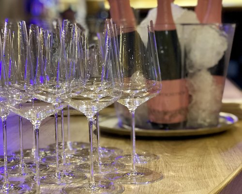 Hotel Sonnenhof Leere Weingläser und Champagnerflaschen im Eis auf Holztisch