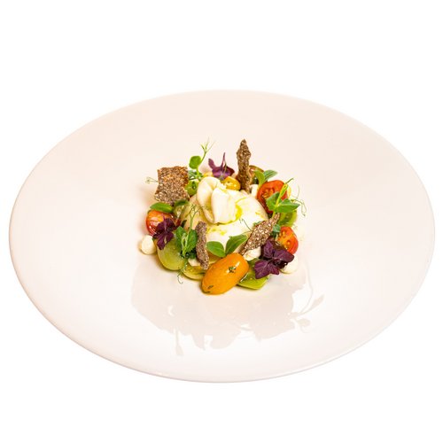 Hotel Sonnenhof Gourmetgericht mit Burrata, Tomaten, Kräutern und knusprigen Brotscheiben auf weißem Teller