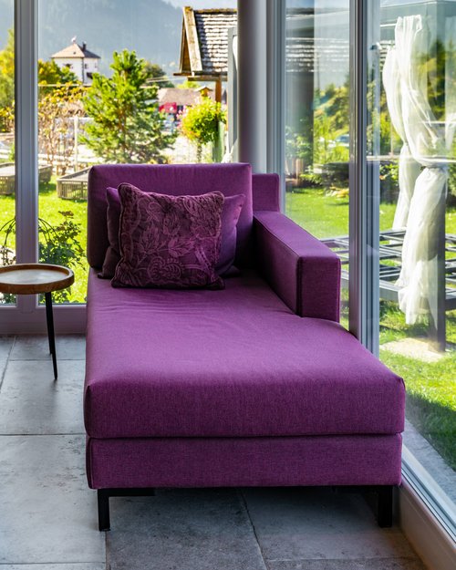 Hotel Sonnenhof Purple chaise lounge by large window with mountain view
