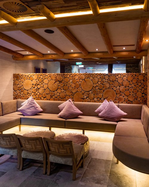 Hotel Sonnenhof Cozy lounge with wooden ceiling, sofas, and wall decorated with wooden log slices
