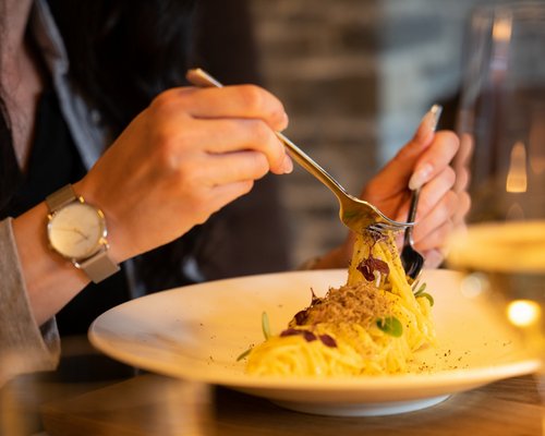 Hotel Sonnenhof Frau isst Spaghetti mit Trüffel in einem Restaurant