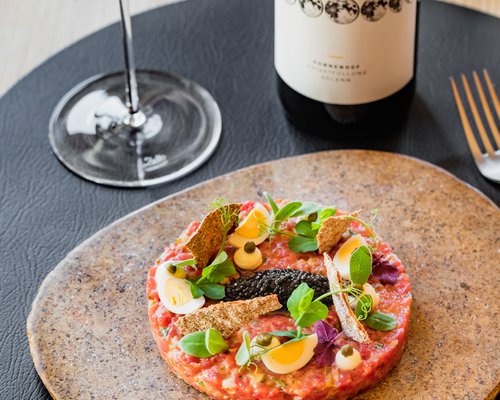 Hotel Sonnenhof Rinder-Tartar mit Eiern, Kräutern, Kaviar, serviert mit Rotwein und Flasche