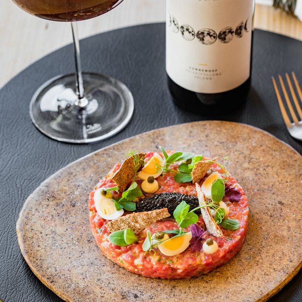 Hotel Sonnenhof Rinder-Tartar mit Eiern, Kräutern, Kaviar, serviert mit Rotwein und Flasche