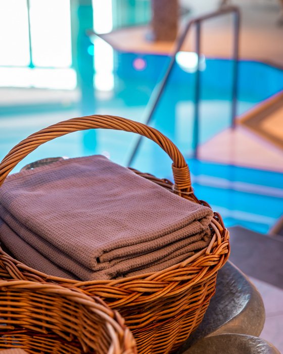 Hotel Sonnenhof Gefaltete Handtücher im Korb neben einem Schwimmbad