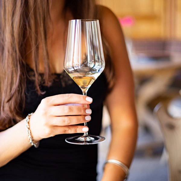 Hotel Sonnenhof Frau hält Weinglas mit weißem Wein in einem Restaurant