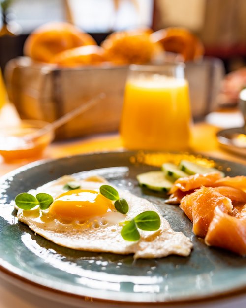 Hotel Sonnenhof Fried egg with smoked salmon, cucumber slices and orange juice for breakfast